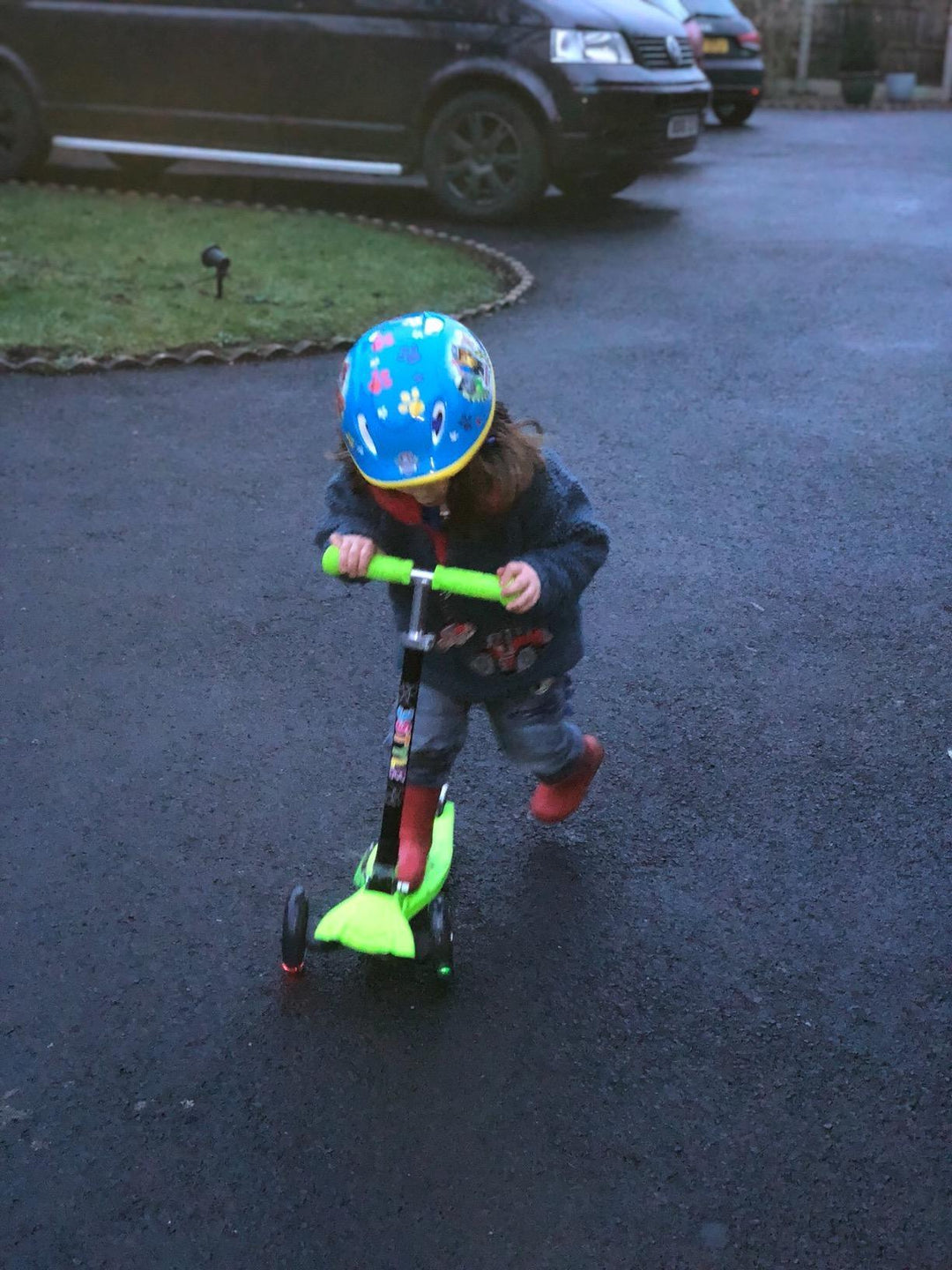 child riding a 3 wheel scooter